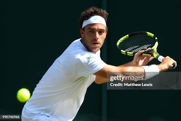 Marco Cecchinato of Italy returns against Alex De Minaur of Australia during their Men's Singles first round match on day two of the Wimbledon Lawn...