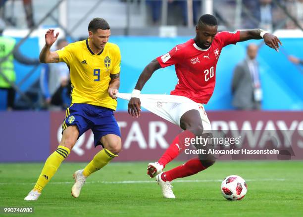 Marcus Berg of Sweden holds back Johan Djourou of Switzerland during the 2018 FIFA World Cup Russia Round of 16 match between Sweden and Switzerland...