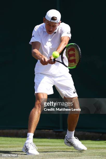 Alex De Minaur of Australia returns against Marco Cecchinato of Italy during their Men's Singles first round match on day two of the Wimbledon Lawn...