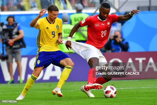 Sweden's forward Marcus Berg fights for the ball with Switzerland's defender Johan Djourou during the Russia 2018 World Cup round of 16 football...