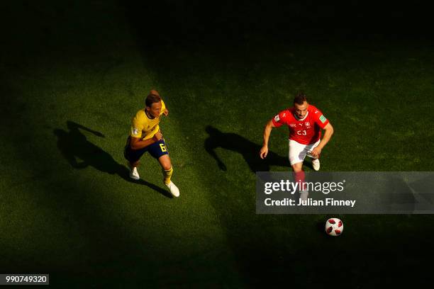 Xherdan Shaqiri of Switzerland is challenged by Ludwig Augustinsson of Sweden during the 2018 FIFA World Cup Russia Round of 16 match between Sweden...