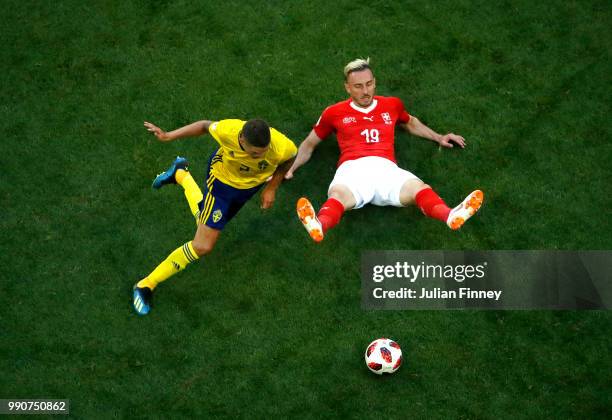 Josip Drmic of Switzerland is challenged by Mikael Lustig of Sweden during the 2018 FIFA World Cup Russia Round of 16 match between Sweden and...
