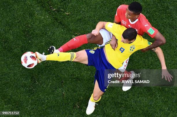 Sweden's forward Marcus Berg vies with Switzerland's defender Manuel Akanji during the Russia 2018 World Cup round of 16 football match between...