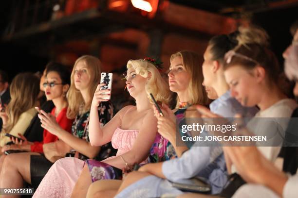 Visitor takes a picture during a fashion show of the label "Lena Hoschek" during the Fashion Week in Berlin on July 03, 2018. / Germany OUT