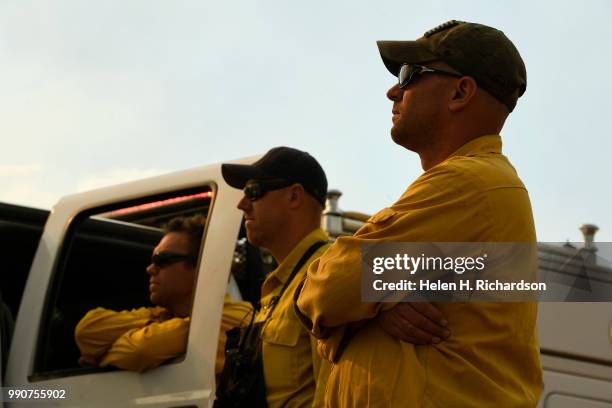 Arvada Fire Department wildland firefighters from left to right Justin Cotsamire, Patrick Jungels, and Jeremy Gaccetta, on Brush 58, watch for hot...