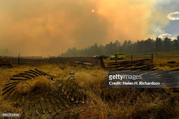 Fire engines are parked in a fieldnear a home as they fight the Weston Pass Fire burns in the background on July 2, 2018 near Fairplay, Colorado. The...