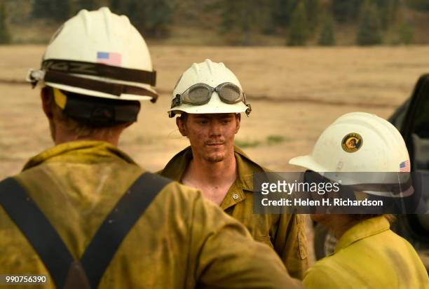Cody Cowan, middle, and other members of the Craig Hotshots return to their crew cabs after a long day of fighting the Weston Pass Fire on July 2,...