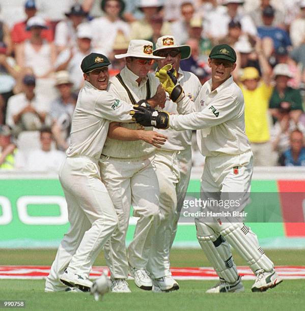 Mark Waugh is congratualted by his teammates after catching Mike Atherton off the bowling of Jason Gillespie for 57 runs during the opening day of...