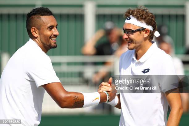 Nick Kyrgios of Australia shakes hands with Denis Istomin of Uzbekistan after their Men's Singles first round match on day two of the Wimbledon Lawn...