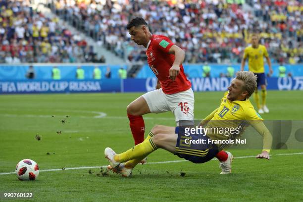 Emil Forsberg of Sweden tackles Blerim Dzemaili of Switzerland during the 2018 FIFA World Cup Russia Round of 16 match between Sweden and Switzerland...