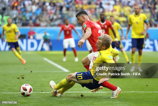 Emil Forsberg of Sweden tackles Blerim Dzemaili of Switzerland during the 2018 FIFA World Cup Russia Round of 16 match between Sweden and Switzerland...