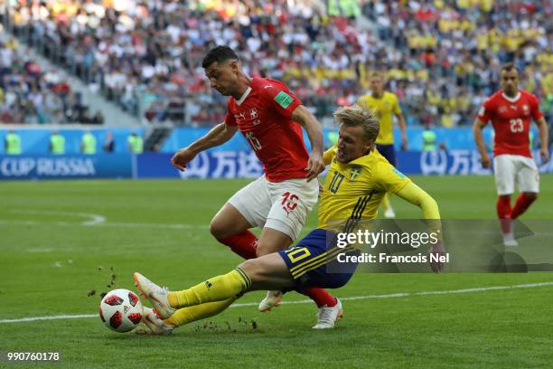 Emil Forsberg of Sweden tackles Blerim Dzemaili of Switzerland during the 2018 FIFA World Cup Russia Round of 16 match between Sweden and Switzerland...