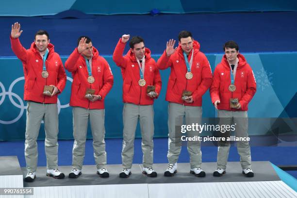 Switzerland's Dominik Maerki , Valentin Tanner, Peter de Cruz, Claudio Paetz and Benoit Schwarz celebrate winning bronze at the Curling Centre in...