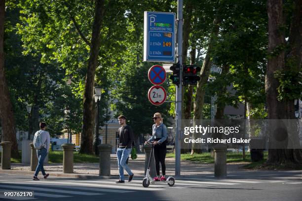 Woman wearing pink slippers rides her scooter across a junction on Slovenska Cesta in the Slovenian capital, Ljubljana, on 25th June 2018, in...