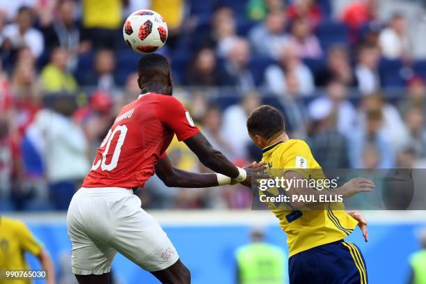 Switzerland's defender Johan Djourou heads the ball with Switzerland's forward Haris Seferovic during the Russia 2018 World Cup round of 16 football...