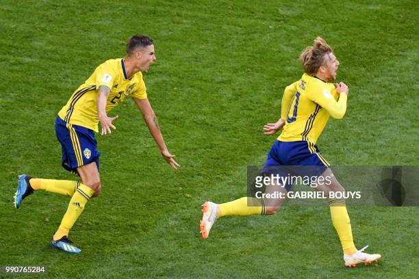 Sweden's midfielder Emil Forsberg celebrates with Sweden's defender Mikael Lustig after scoring during the Russia 2018 World Cup round of 16 football...