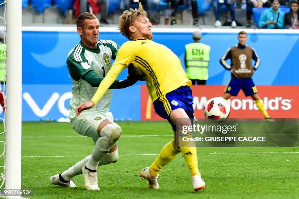 Sweden's goalkeeper Robin Olsen and midfielder Emil Forsberg defend their goal during the Russia 2018 World Cup round of 16 football match between...