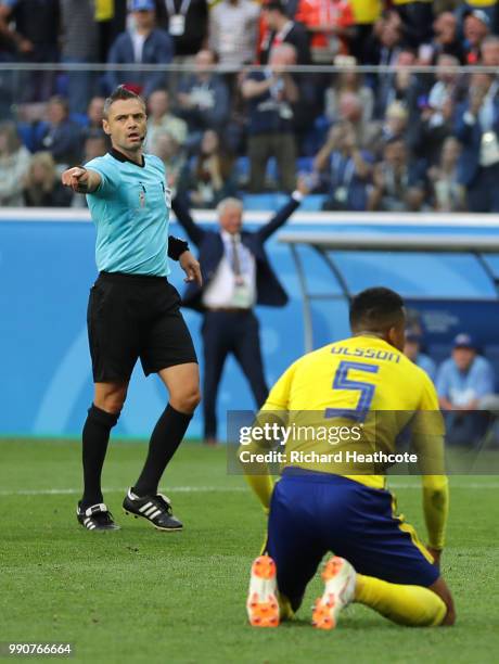 Referee Damir Skomina points the penalty spot for a penalty which will be canceled due to a VAR review during the 2018 FIFA World Cup Russia Round of...
