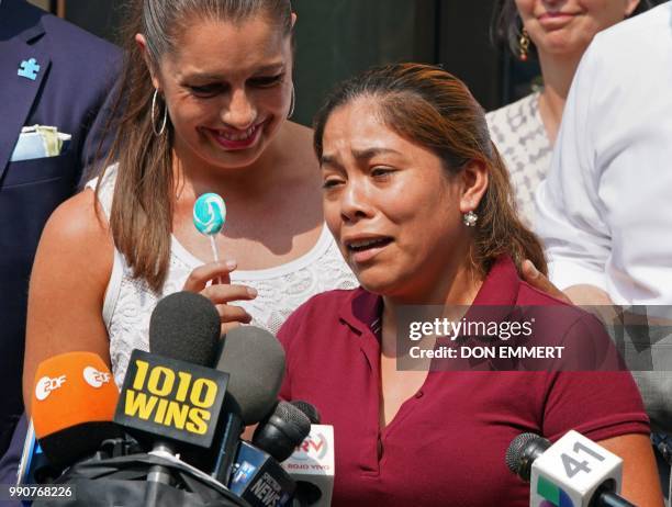 Yeni Marciela Gonzalez Garcia, of Guatemala, the mother of three children at the Cayuga House in Harlem, holds up a lollipop as she speaks at a news...