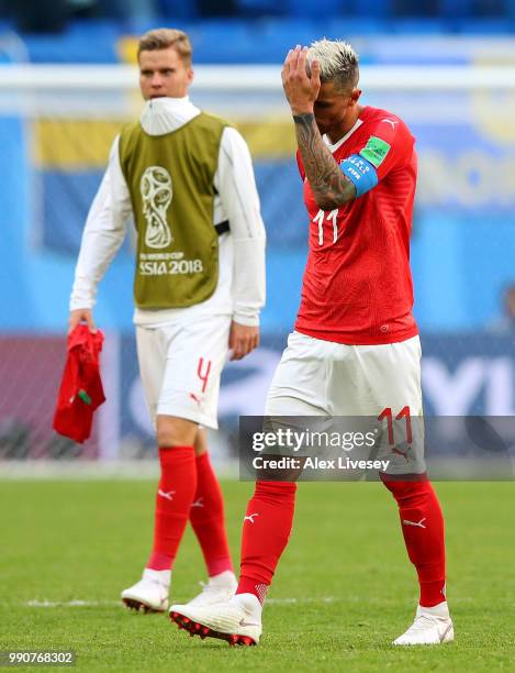 Nico Elvedi and Valon Behrami of Switzerland shows his dejection following the 2018 FIFA World Cup Russia Round of 16 match between Sweden and...