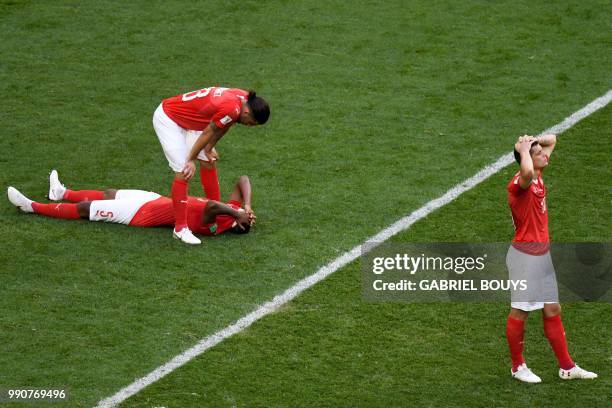 Switzerland's defender Ricardo Rodriguez, Switzerland's defender Manuel Akanji and Switzerland's forward Mario Gavranovic look dejected at the end of...