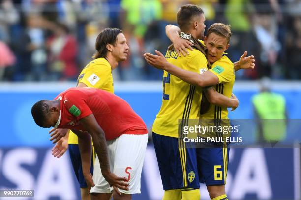 Sweden's defender Ludwig Augustinsson and Sweden's defender Mikael Lustig celebrate their victory past Switzerland's defender Manuel Akanji at the...