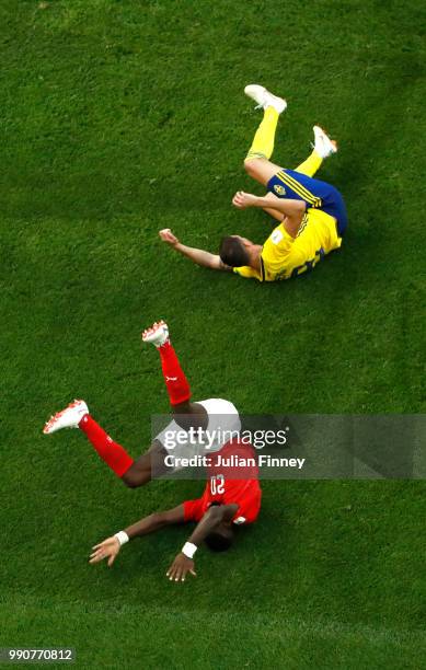 Johan Djourou of Switzerland collides with Marcus Berg of Sweden during the 2018 FIFA World Cup Russia Round of 16 match between Sweden and...