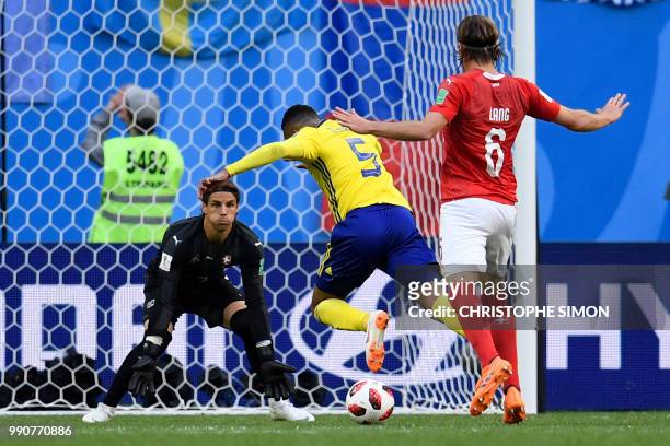 Switzerland's defender Michael Lang fouls Sweden's defender Martin Olsson as he advances towards Switzerland's goalkeeper Yann Sommer during the...