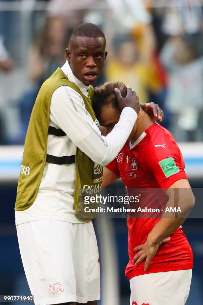 Xherdan Shaqiri of Switzerland is consoled by Deni Zakaria of Switzerland at the end of the 2018 FIFA World Cup Russia Round of 16 match between...