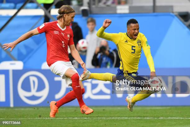 Sweden's defender Martin Olsson falls in front of Switzerland's defender Michael Lang during the Russia 2018 World Cup round of 16 football match...