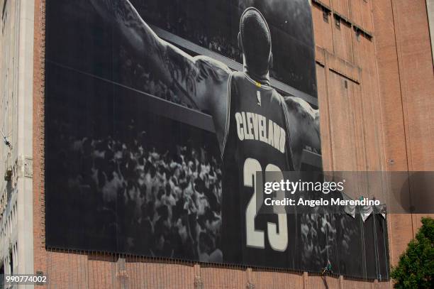 Workers take down the LeBron James banner from the Sherwin Williams building on the corner of Ontario and West Huron on July 3, 2018 in Cleveland,...