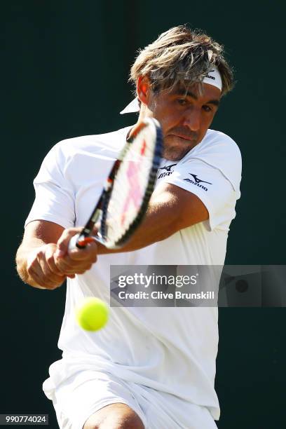 Marcos Baghdatis of Cyprus returns against Dominic Thiem of Austria during their Men's Singles first round match on day two of the Wimbledon Lawn...