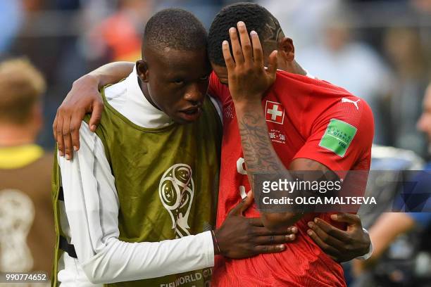 Switzerland's midfielder Gelson Fernandes comforts defender Manuel Akanji after the team lost the Russia 2018 World Cup round of 16 football match...