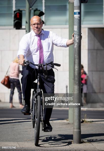 July 2018, Germany, Berlin: Peter Altmaier , Federal Minister for Economy and Energy, leaving on his bicycle the CDU party heardquarters, the Konrad...