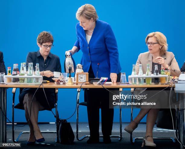 July 2018, Germany, Berlin: Angela Merkel, German Chancellor and the CDU's federal chairwoman, pouring coffee for Annegret Kramp-Karrenbauer , the...