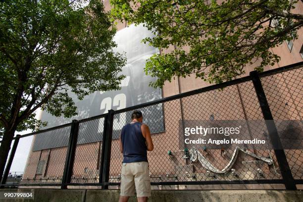 Man watches as workers remove the LeBron James banner from the Sherwin Williams building on the corner of Ontario and West Huron on July 3, 2018 in...