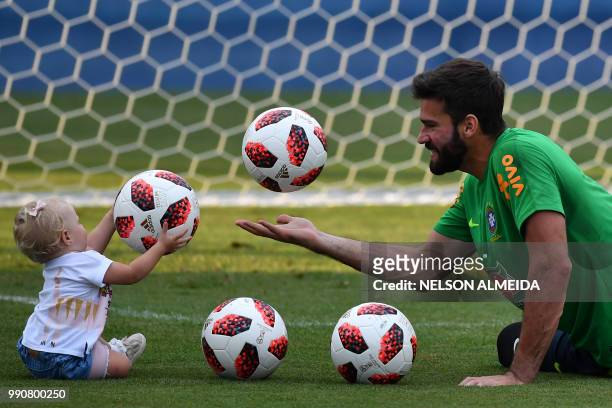 Brazil's goalkeeper Alisson players with his daughter Helena during a training session at the Yug Sport Stadium in Sochi, on July 3 ahead of the...