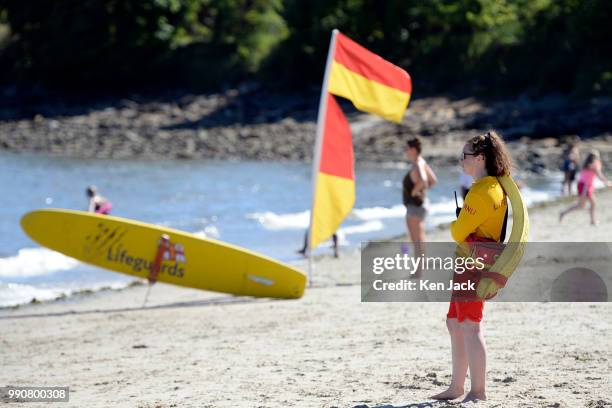 An RNLI lifeguard keeps watch as people enjoy the sun on Silver Sands beach at the start of the Scottish school holidays as the heatwave continues,...