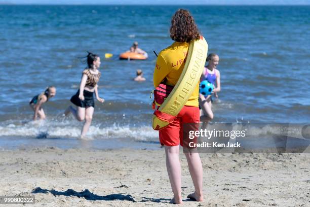 An RNLI lifeguard keeps watch as people enjoy the sun on Silver Sands beach at the start of the Scottish school holidays as the heatwave continues,...