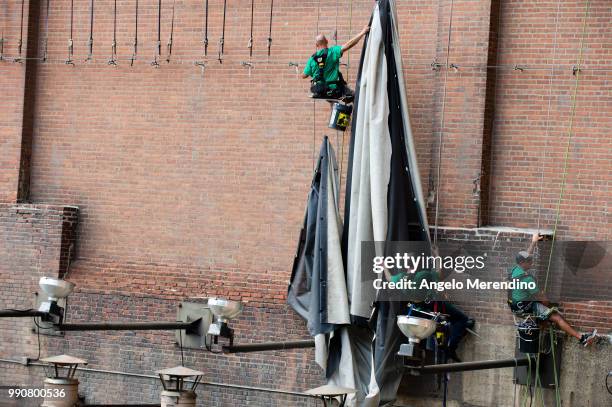 Workers take down the LeBron James banner from the Sherwin Williams building on the corner of Ontario and West Huron on July 3, 2018 in Cleveland,...