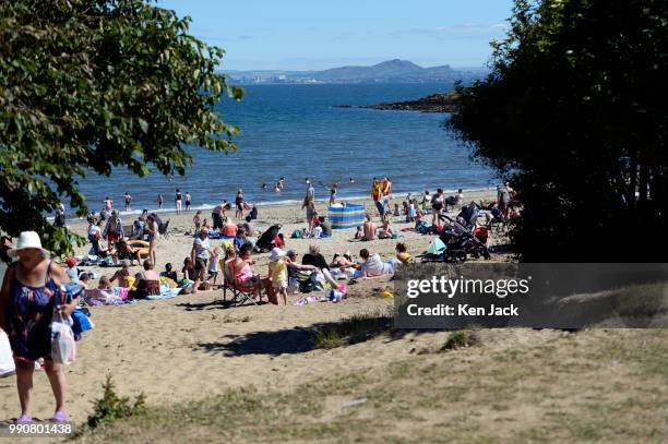 People enjoy the sun on Silver Sands beach at the start of the Scottish school holidays as the heatwave continues, with Edinburgh in the background...