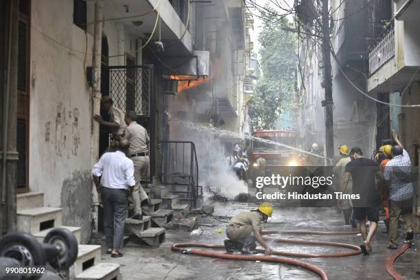Fire-fighters douse a fire that broke out in a building in Bazar Lane, Bhogal, on July 3, 2018 in New Delhi, India.