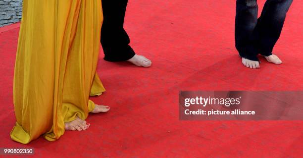 Dpatop - 02 July 2018, Germany, Munich: Actress Meret Becker , musician Blixa Bargeld, and actress Amanda Plummer, arriving barefoot to the CineMerit...