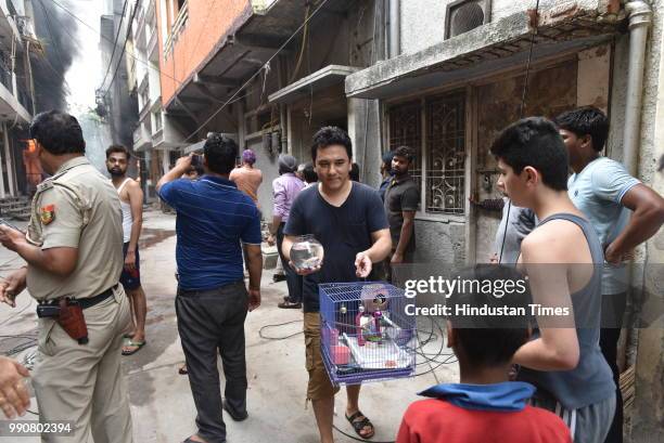 Man rushes to save his pets from his apartment which is a few blocks away from the building which caught fire in Bazar Lane, Bhogal on July 3, 2018...