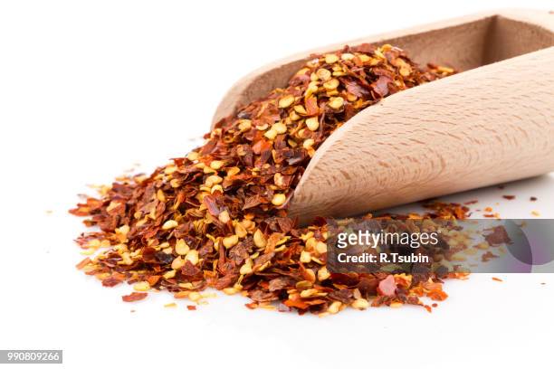 the pile of a crushed red pepper, dried chili flakes and seeds isolated on white background in a scoop - seeded stock pictures, royalty-free photos & images
