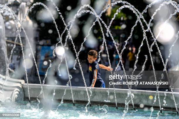 Child cools off in a fountain in Skopje on July 3 during a period of hot weather in Macedonia where temperatures have reached 33 Celsius.