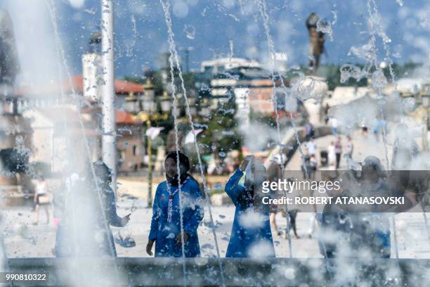 Young women cool off in a fountain in Skopje on July 3 during a period of hot weather in Macedonia where temperatures have reached 33 Celsius.