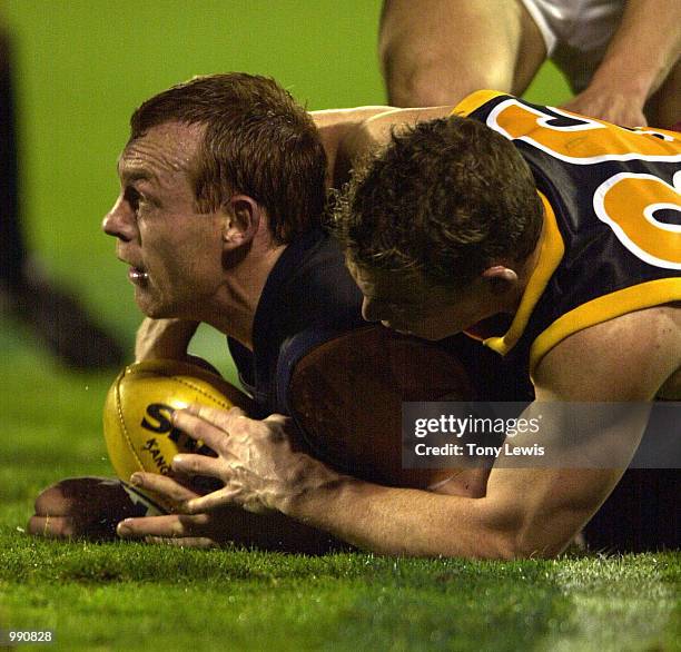 Mark Bickley for Adelaide dives on Adrian Hickmott for Carlton in the match between the Carlton Blues and the Adelaide Crows in round 19 of the AFL...