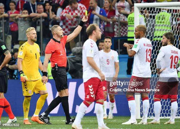 Mathias Jorgensen of Denmark receives a yellow card from referee Nestor Pitana during the 2018 FIFA World Cup Russia Round of 16 match between...