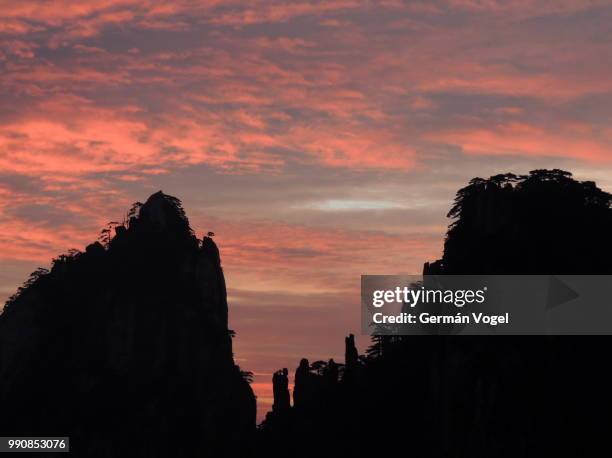 mountain silhouettes and beautiful sunrise sky, huangshan, china - huangshan city anhui province stock pictures, royalty-free photos & images